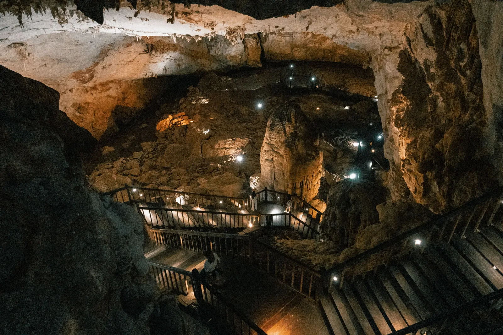Illuminated stalactite chamber inside Paradise Cave, Phong Nha, Vietnam, with a wooden walkway