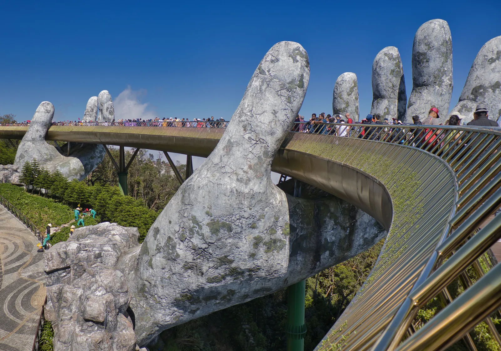 The Golden Bridge held up by giant stone hands at Ba Na Hills near Da Nang, Vietnam, in colour daylight