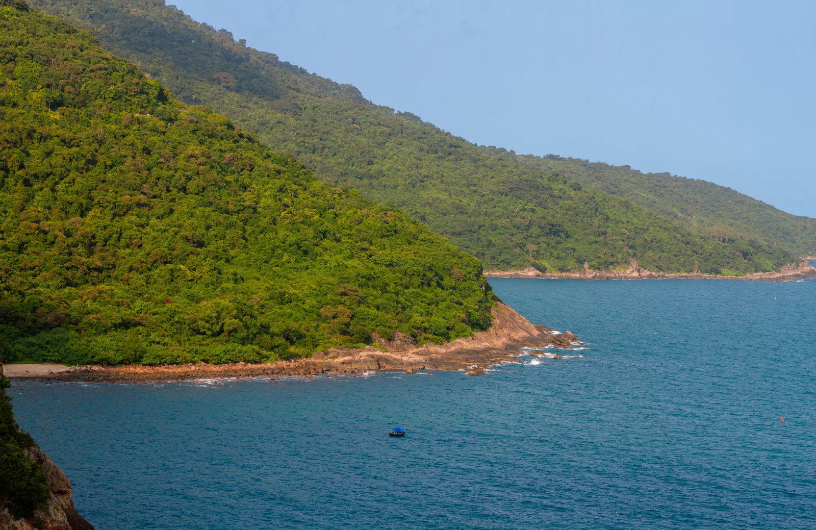 A secluded cove backed by forested hills on the Son Tra peninsula near Da Nang, Vietnam