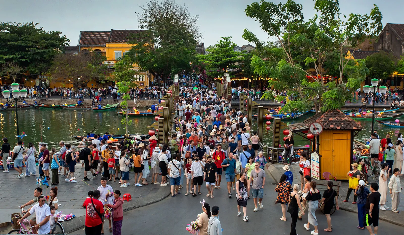 Wooden boats and coloured lanterns along the riverfront in Hoi An old town, Vietnam, in the afternoon