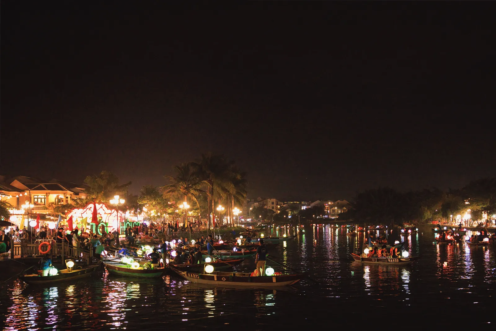 Silk lanterns reflected in the river at night in the old town of Hoi An, Vietnam
