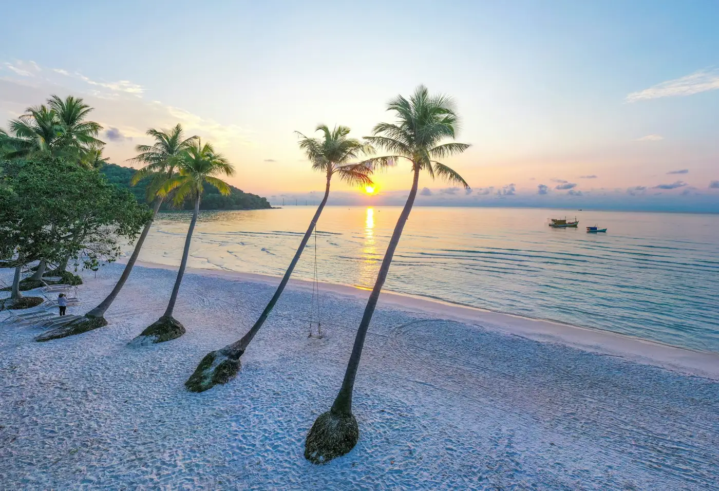A quiet white sand beach with palms and clear water on a Vietnamese island