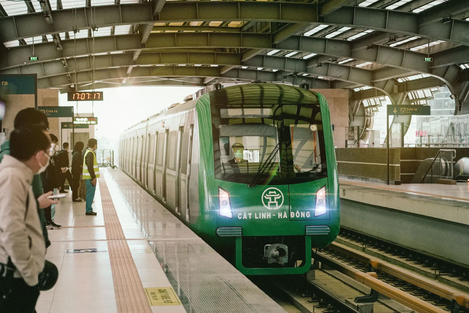 A green Cat Linh to Ha Dong metro train waiting at an elevated station platform in Hanoi, Vietnam