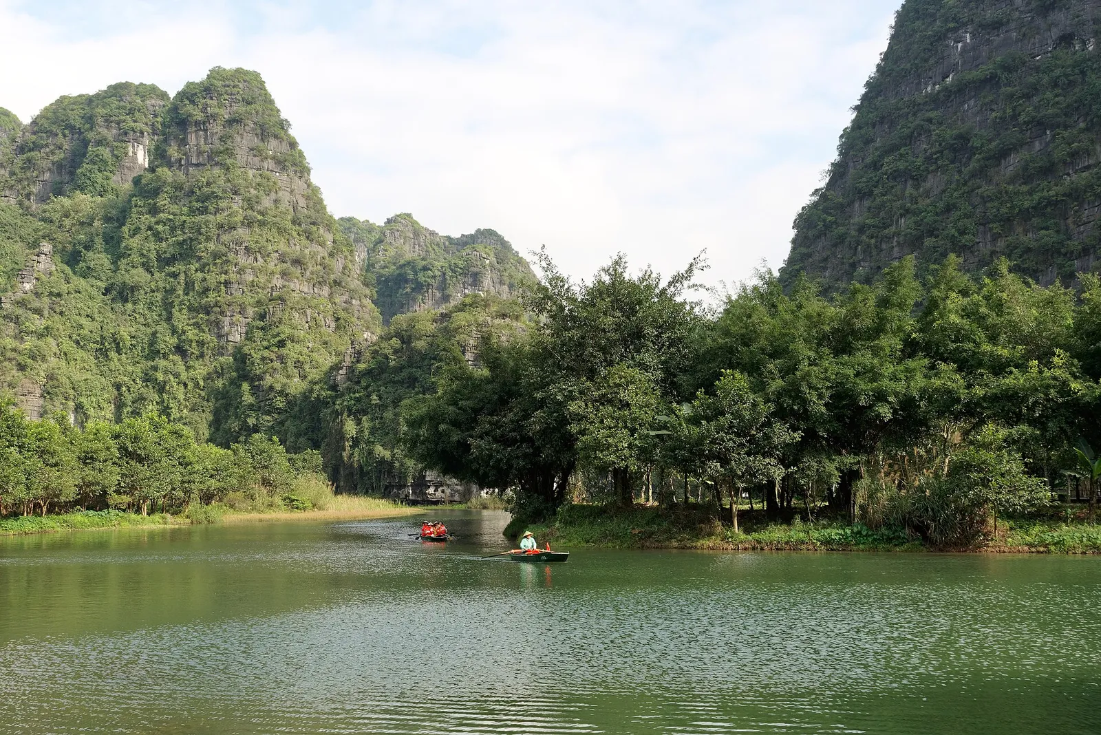 A river between green limestone karsts in Vietnam in daylight