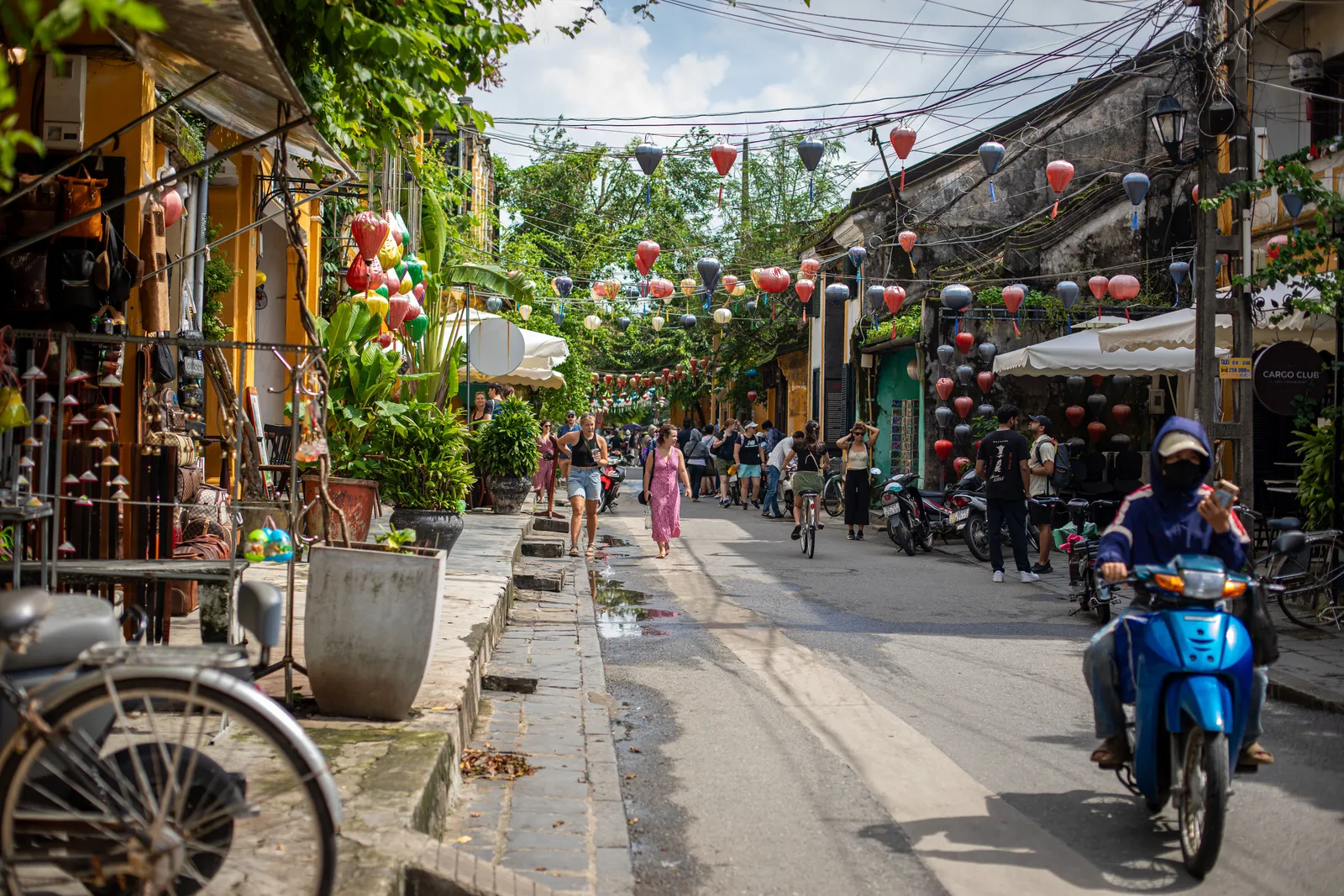 A family walking through a lantern-lit pedestrian street in Hoi An old town, Vietnam