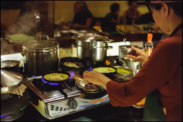 A restaurant's open kitchen with a cook working at the burners