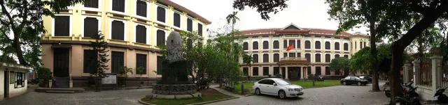 A yellow colonial museum building with a stone sculpture in front