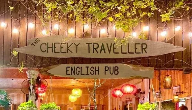 Wooden signs lit by a string of bulbs above an entrance with red paper lanterns