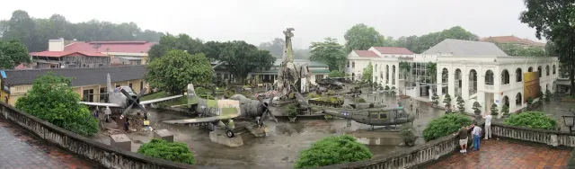 Aircraft and military vehicles on outdoor display among trees