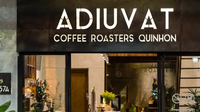 A dark metal facade with large white letters above a lit display window