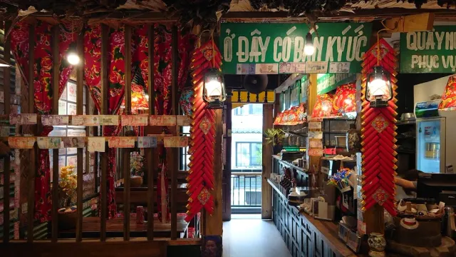 A retro space with a wooden lattice, hanging red holiday decorations, oil lamps and a loaded counter