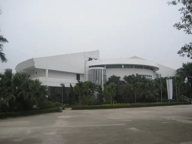 A modern white museum building shaped like a bronze drum