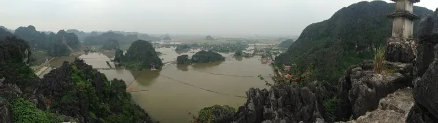 A view from height over a river winding between limestone peaks and green fields