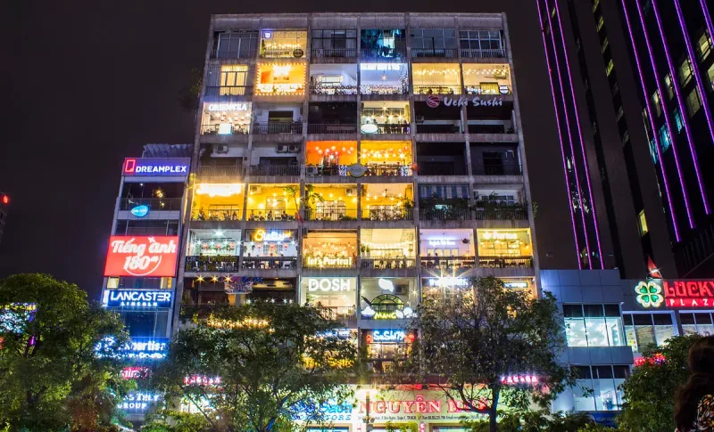 The Cafe Apartment on Nguyen Hue lit up at night, a cafe on every balcony