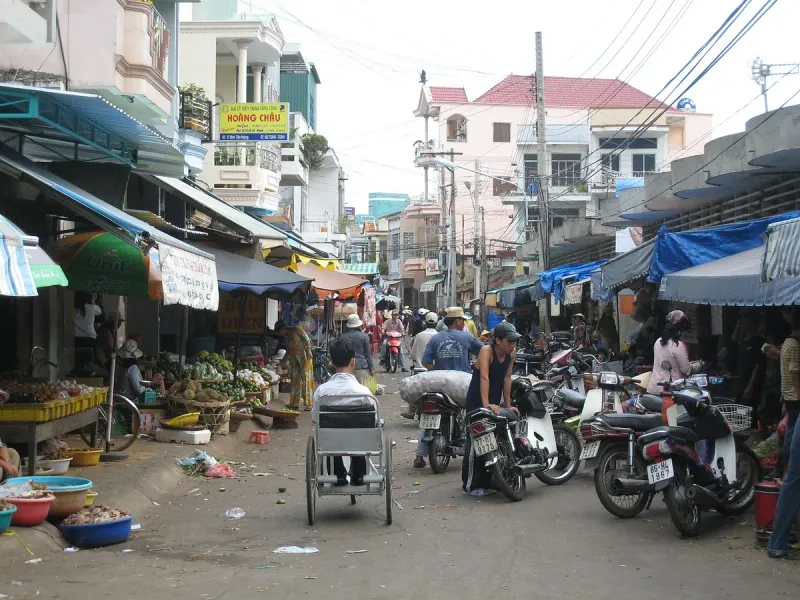 A market lane in Phan Thiet lined with stalls and motorbikes