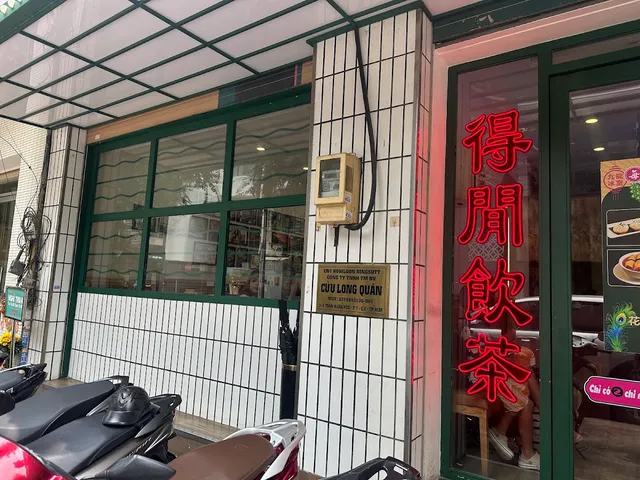 A white tiled frontage with red neon Chinese characters on the glass