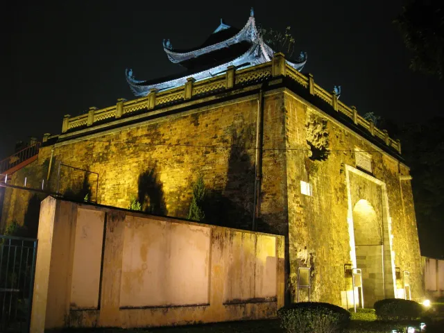 A fortified stone gate lit gold against an evening sky