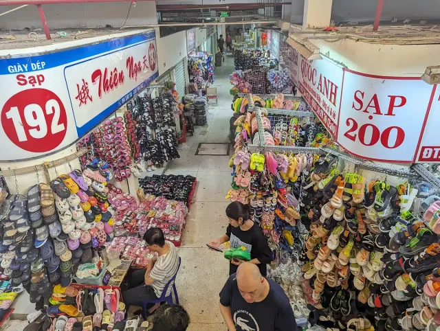 Market aisles piled with goods under yellow price signs