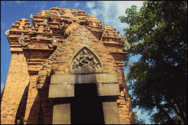 The brick facade of a Cham tower with carving above the doorway