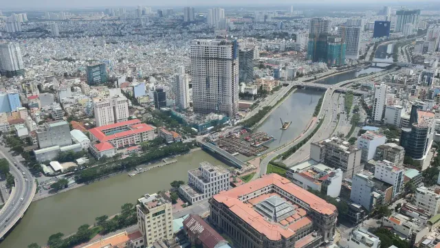 An aerial view over a dense city and the river crossing it