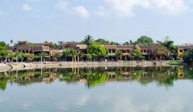 Low merchant houses with tiled roofs reflected in the river