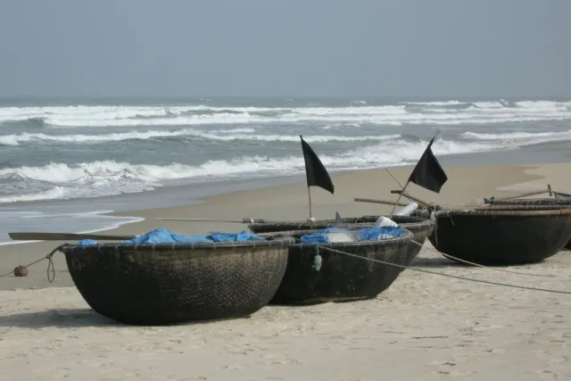 Traditional round basket boats on the sand facing the surf