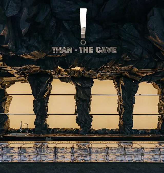 A dark cave style rock wall above a counter made of glass bricks