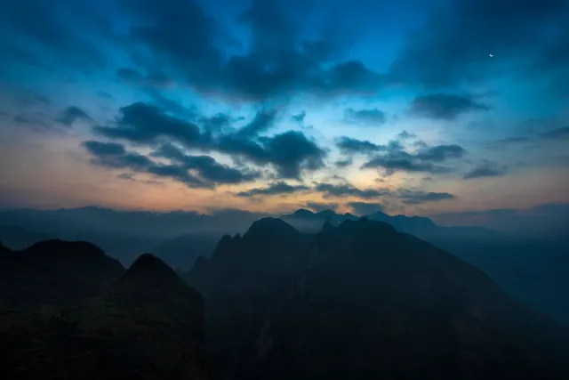 A sharp mountain ridge above a deep valley under a blue sky
