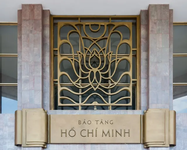 A gilded decorative screen in a lotus pattern above the museum's stone sign