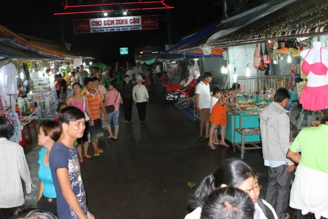 A night market lane with lit stalls and shoppers