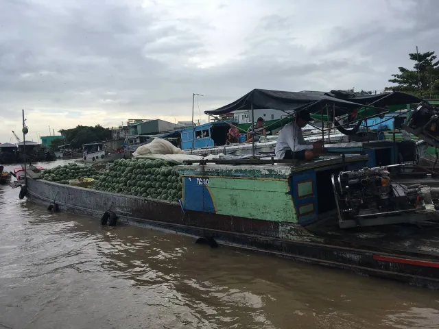 Boats loaded with produce moored side by side on the river