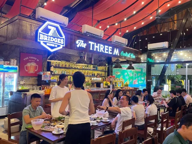 A bustling space with neon signs, a red fabric canopy, a bottle bar and tables full of diners