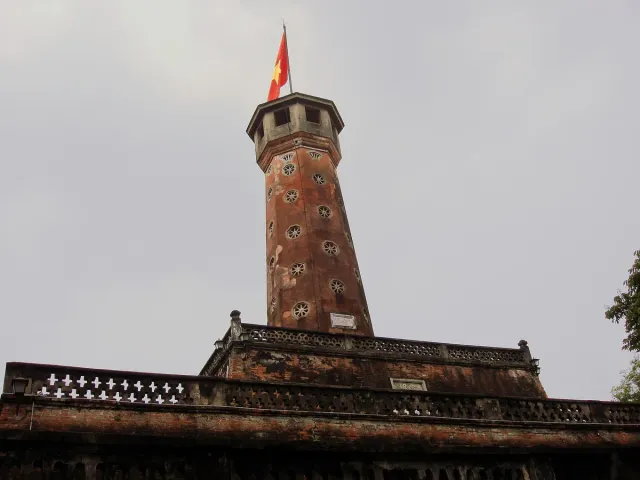 A hexagonal red brick flag tower with a flag flying at the top